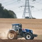 Image of tractor in field with pylon in background